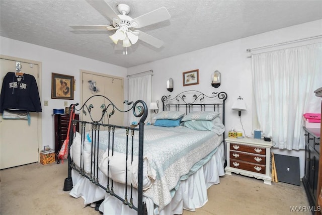 bedroom with light colored carpet, a textured ceiling, and a ceiling fan