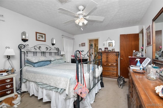 bedroom featuring light colored carpet, a textured ceiling, and ceiling fan