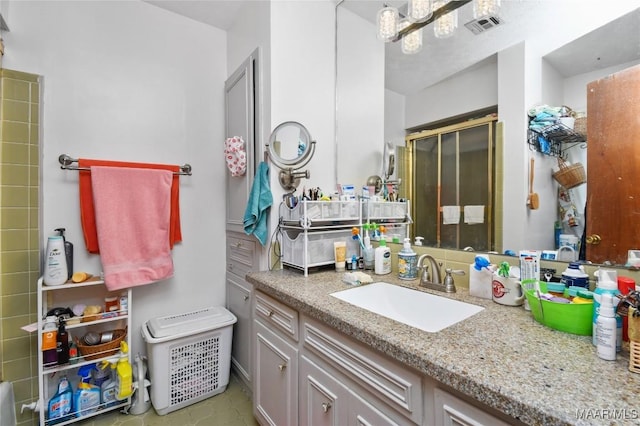 bathroom featuring a stall shower, vanity, and a chandelier