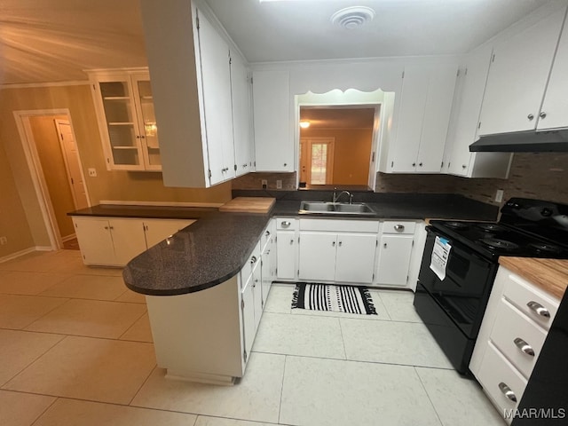 kitchen featuring black range with electric stovetop, under cabinet range hood, a sink, a peninsula, and dark countertops