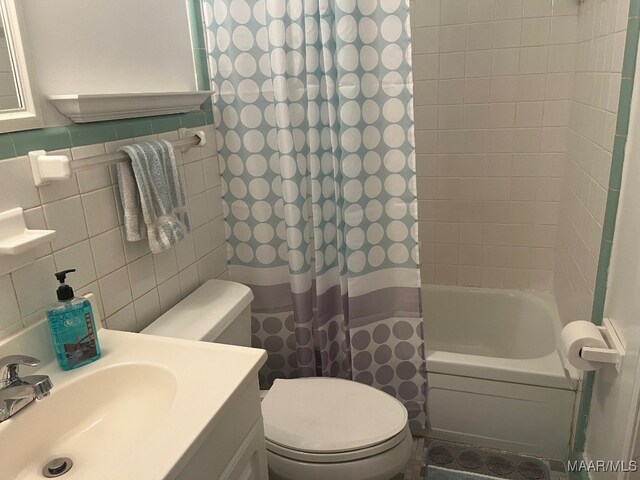 bathroom featuring toilet, tile walls, shower / tub combo, and vanity