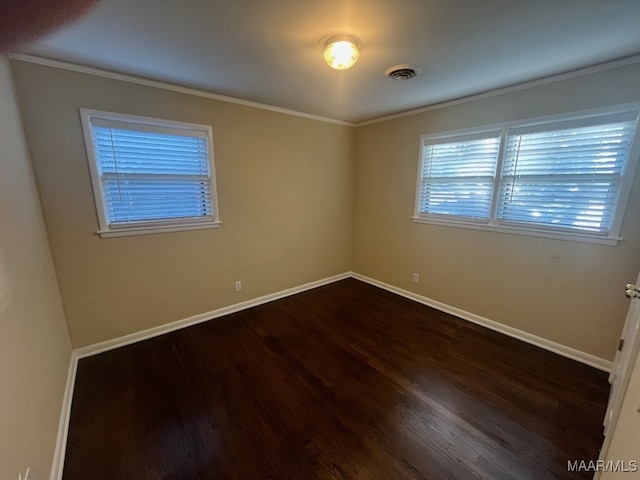 spare room with dark wood-type flooring, baseboards, and ornamental molding