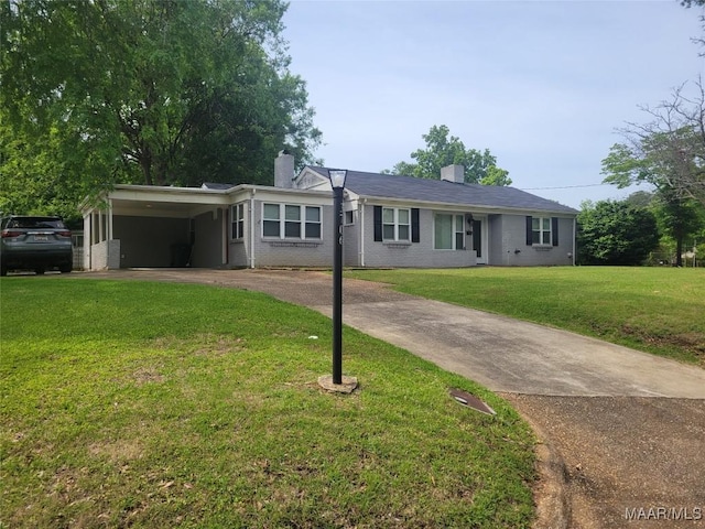 ranch-style home with driveway, a chimney, a front yard, and an attached carport