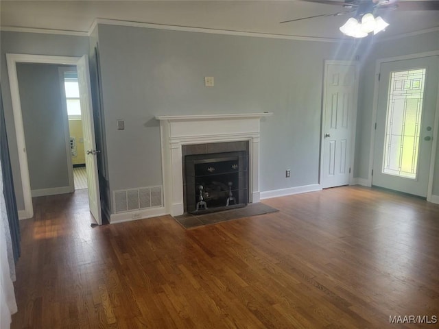 unfurnished living room featuring ornamental molding, wood finished floors, baseboards, and healthy amount of natural light