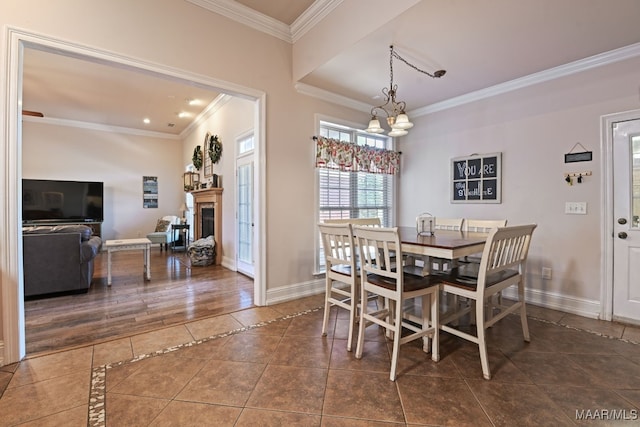 65 Copper Ridge Ct, Deatsville, AL 36022 - dining area featuring tile patterned floors, ornamental molding, a chandelier, a fireplace, and inlaid floor details