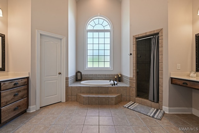 65 Copper Ridge Ct, Deatsville, AL 36022 - full bath with vanity, a garden tub, a stall shower, tile patterned floors, and a high ceiling