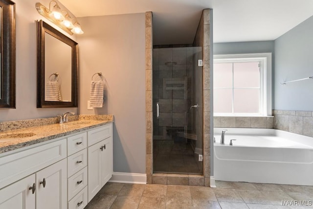 full bathroom featuring a garden tub, double vanity, a stall shower, and baseboards