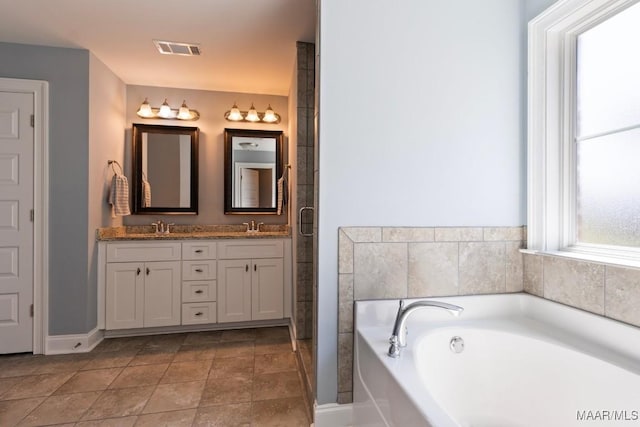 bathroom featuring a garden tub, double vanity, and baseboards