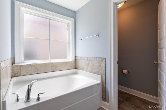 full bathroom featuring a garden tub and baseboards