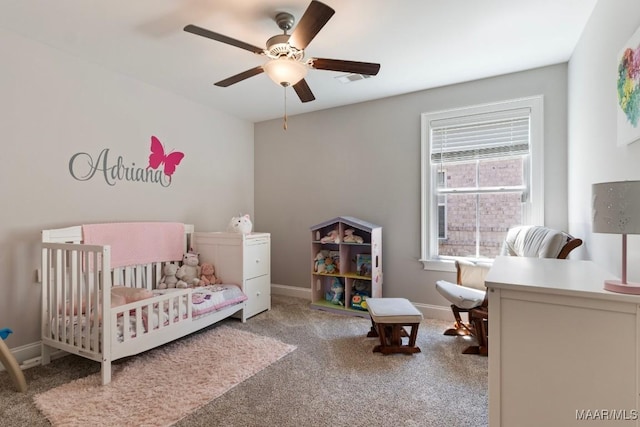 bedroom with a crib, carpet flooring, and baseboards