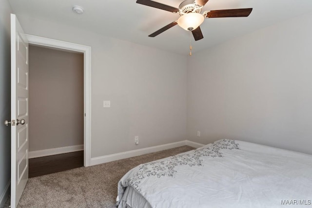 carpeted bedroom featuring baseboards and a ceiling fan