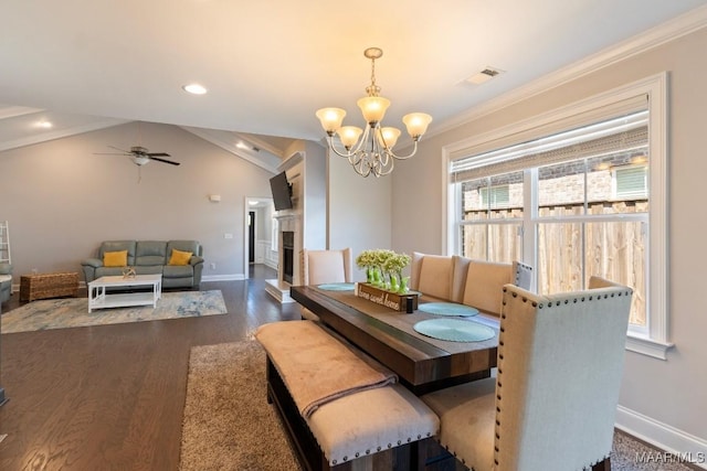dining room featuring baseboards, a chandelier, dark wood-style floors, crown molding, and a ceiling fan