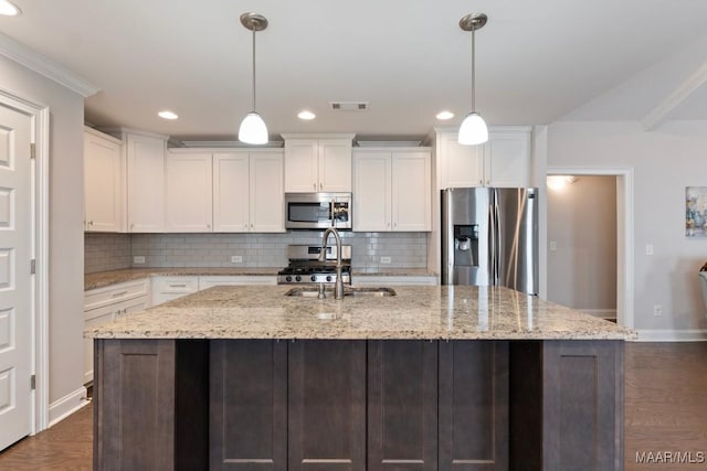 kitchen with appliances with stainless steel finishes, tasteful backsplash, white cabinetry, a sink, and recessed lighting
