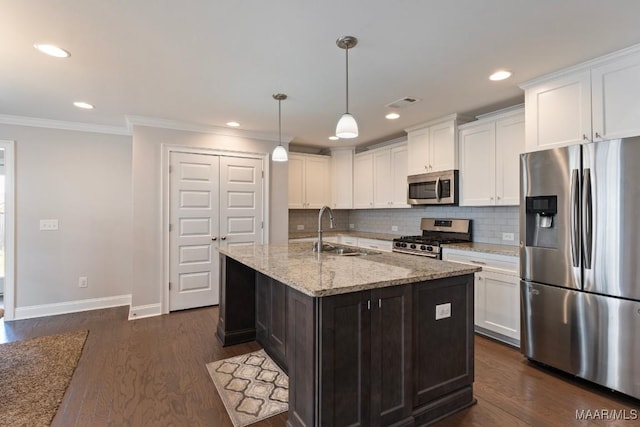kitchen featuring stainless steel appliances, a sink, baseboards, crown molding, and white cabinetry