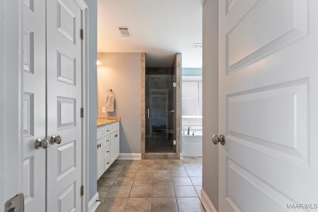 full bathroom with a stall shower, vanity, a bathtub, and baseboards