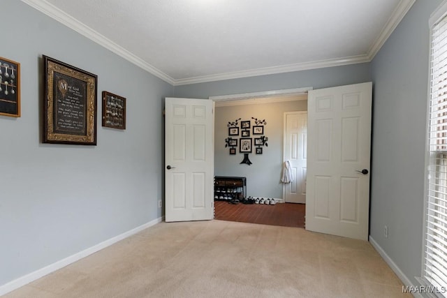 unfurnished bedroom featuring carpet floors, ornamental molding, and baseboards