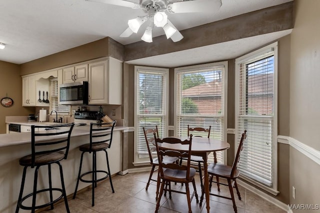 dining space with baseboards, light tile patterned floors, and ceiling fan