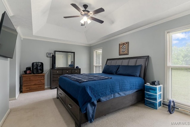 bedroom with light carpet, a tray ceiling, crown molding, baseboards, and ceiling fan