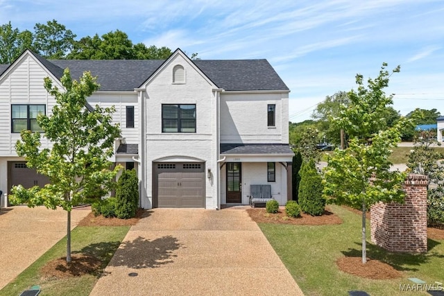 view of front of house featuring driveway, a garage, a shingled roof, a front lawn, and brick siding