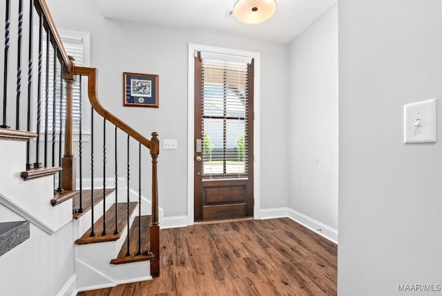 entrance foyer with wood finished floors, stairs, and baseboards