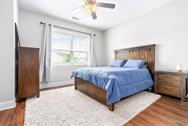 bedroom with wood finished floors, baseboards, and a ceiling fan