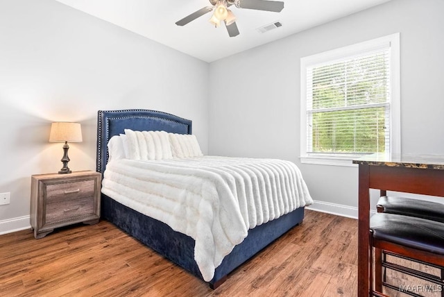 bedroom with baseboards, wood finished floors, and ceiling fan