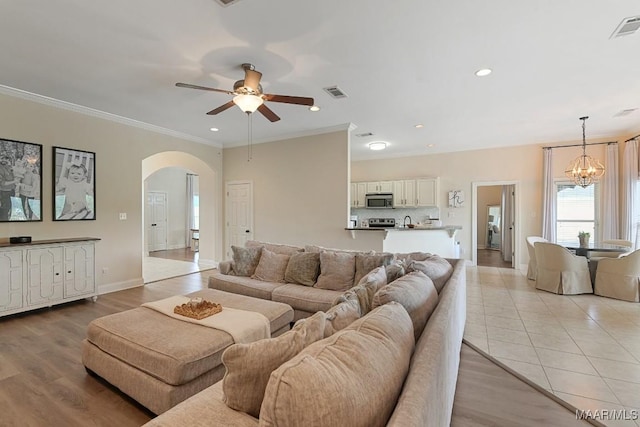 231 Chesson Ct, Fitzpatrick, AL 36029 - living area with arched walkways, a chandelier, a ceiling fan, recessed lighting, and ornamental molding