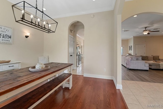 231 Chesson Ct, Fitzpatrick, AL 36029 - dining room featuring arched walkways, ceiling fan, crown molding, wood finished floors, and baseboards