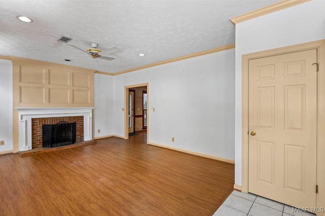1641 Cairnbrook Dr, Montgomery, AL 36106 - unfurnished living room with a ceiling fan, crown molding, a brick fireplace, light wood-style flooring, and baseboards