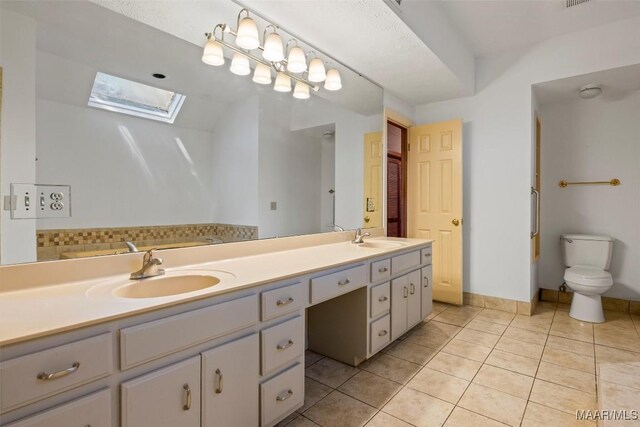 1641 Cairnbrook Dr, Montgomery, AL 36106 - bathroom featuring a skylight, tile patterned flooring, toilet, and double vanity