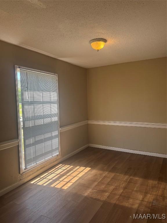 5915 Singleton St, Montgomery, AL 36116 - unfurnished room featuring a textured ceiling, healthy amount of natural light, wood finished floors, and baseboards