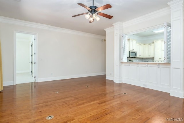 3412 Oak Grove Cir, Montgomery, AL 36116 - unfurnished living room featuring light wood-style flooring, ceiling fan, ornamental molding, decorative columns, and baseboards