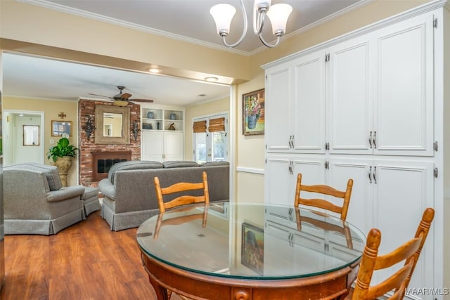 3469 Warrenton Rd, Montgomery, AL 36111 - dining area with ceiling fan, a chandelier, ornamental molding, a fireplace, and wood finished floors