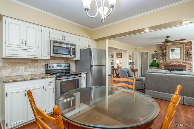 3469 Warrenton Rd, Montgomery, AL 36111 - kitchen with stainless steel appliances, white cabinets, crown molding, backsplash, and open floor plan