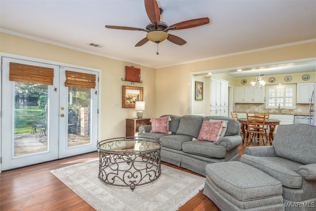 3469 Warrenton Rd, Montgomery, AL 36111 - living room with french doors, a ceiling fan, wood finished floors, ornamental molding, and a chandelier