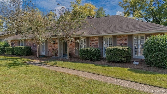 3469 Warrenton Rd, Montgomery, AL 36111 - view of front of house with brick siding, a front lawn, and a shingled roof
