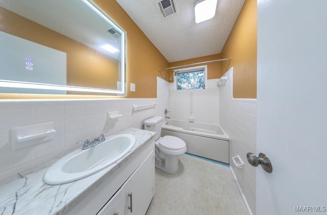 362 Bellehurst Dr, Montgomery, AL 36109 - full bathroom with tile walls, wainscoting, vanity, washtub / shower combination, and a textured ceiling