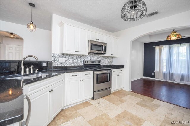 1600 Hawthorne Ln, Prattville, AL 36066 - kitchen with appliances with stainless steel finishes, arched walkways, a sink, decorative backsplash, and a textured ceiling