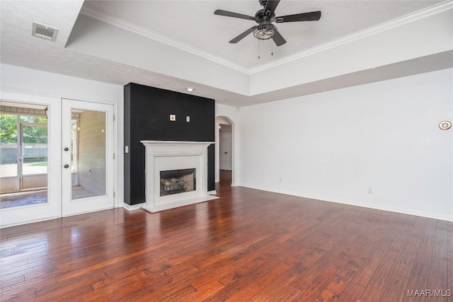 1600 Hawthorne Ln, Prattville, AL 36066 - unfurnished living room featuring a raised ceiling, arched walkways, hardwood / wood-style floors, a ceiling fan, and baseboards