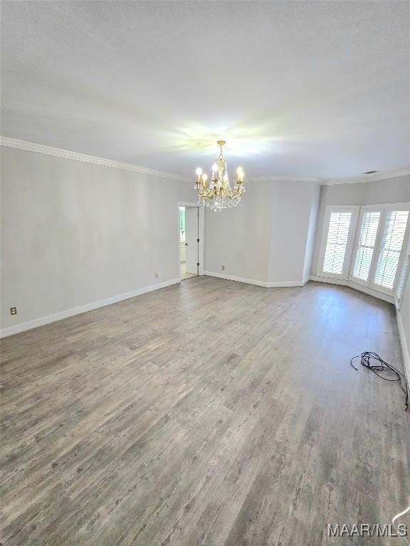 49 Berkeley Rd, Selma, AL 36701 - spare room with ornamental molding, a chandelier, wood finished floors, and baseboards