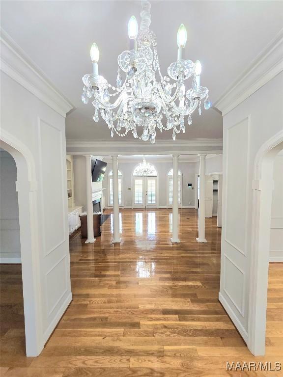 49 Berkeley Rd, Selma, AL 36701 - foyer entrance featuring crown molding, light wood-style floors, arched walkways, a chandelier, and a fireplace