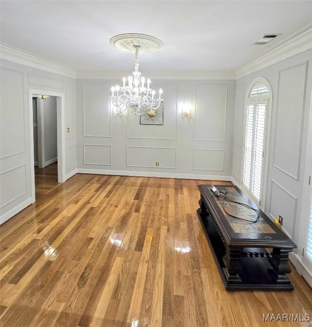 49 Berkeley Rd, Selma, AL 36701 - unfurnished dining area with a decorative wall, a chandelier, crown molding, light wood-style floors, and plenty of natural light