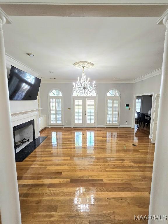 49 Berkeley Rd, Selma, AL 36701 - unfurnished living room featuring crown molding, wood finished floors, a fireplace with flush hearth, a chandelier, and baseboards