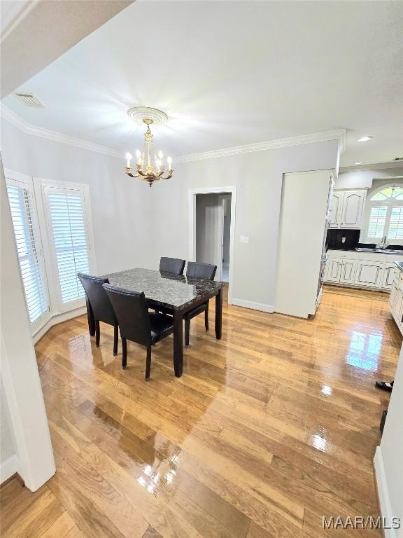 49 Berkeley Rd, Selma, AL 36701 - dining area with a chandelier, light wood-type flooring, ornamental molding, and baseboards