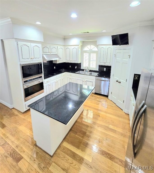 49 Berkeley Rd, Selma, AL 36701 - kitchen with appliances with stainless steel finishes, a sink, under cabinet range hood, ornamental molding, and white cabinetry