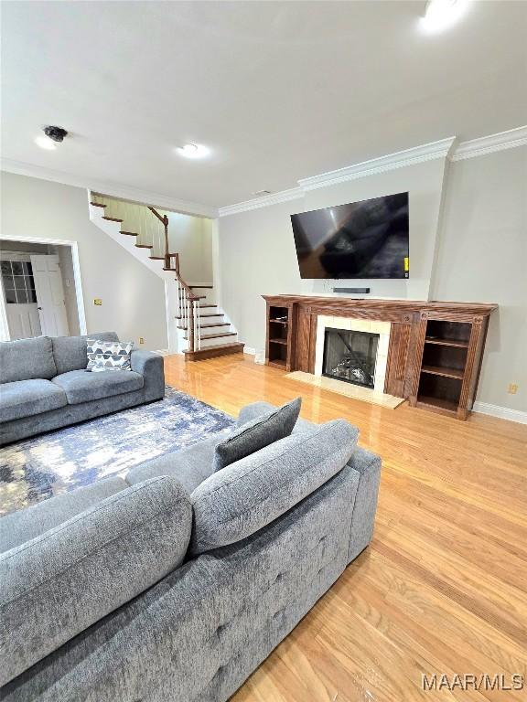 49 Berkeley Rd, Selma, AL 36701 - living room featuring stairway, crown molding, wood finished floors, a fireplace, and baseboards