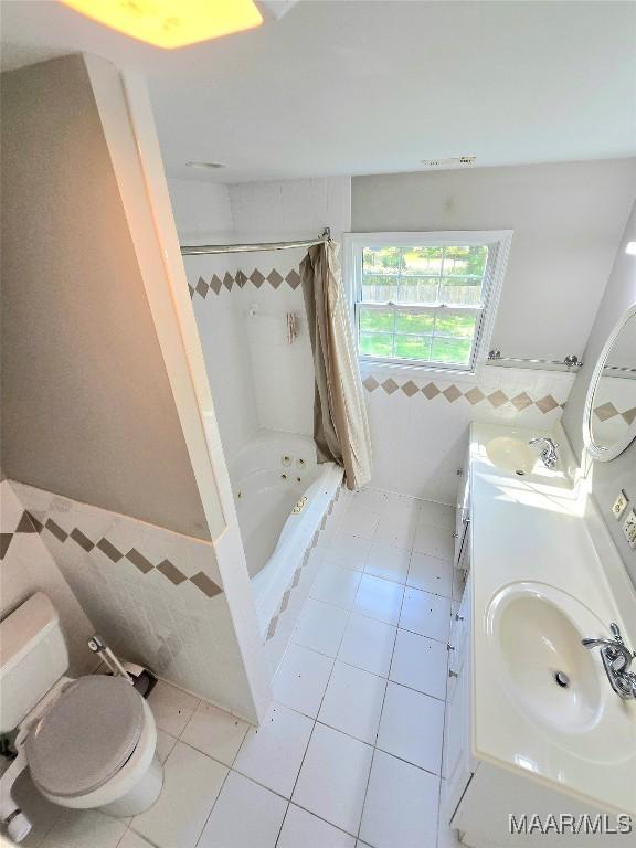 49 Berkeley Rd, Selma, AL 36701 - full bath featuring tile walls, tile patterned flooring, toilet, a wainscoted wall, and shower / bathtub combination with curtain