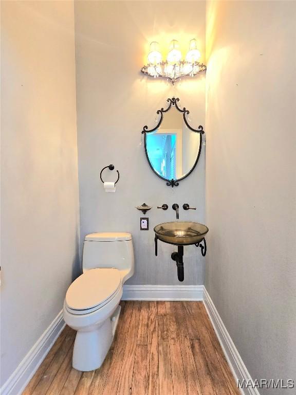 49 Berkeley Rd, Selma, AL 36701 - bathroom featuring wood finished floors, toilet, and baseboards
