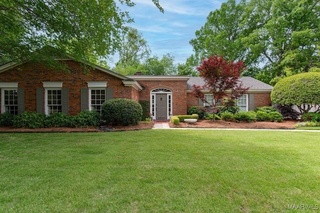 ranch-style home with a front lawn and brick siding