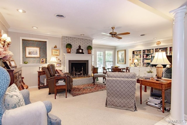 carpeted living area featuring ornamental molding, ceiling fan, a brick fireplace, ornate columns, and recessed lighting